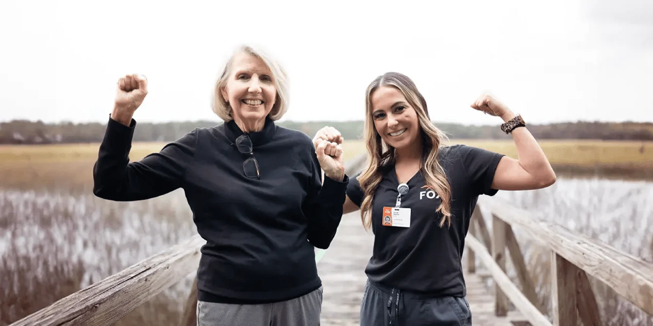A FOX Rehabilitation clinician and her patient smiling outdoors